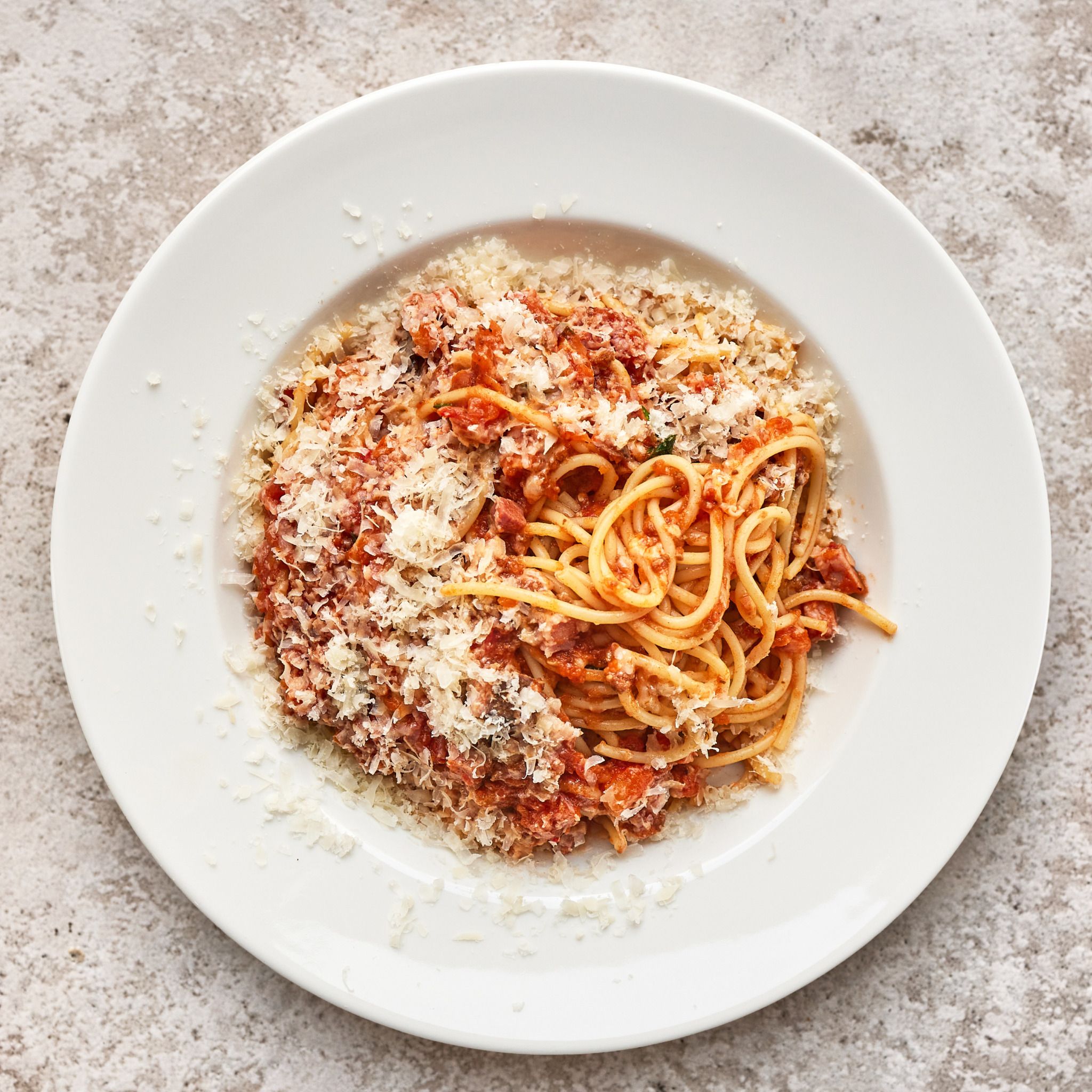 portion of pasta bolonesse on white restaurant plate, top view